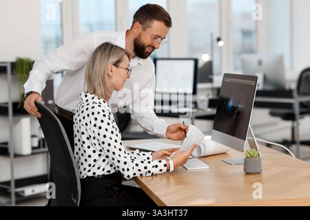 Technicians making digital engineering drawing on computer at desk in office Stock Photo