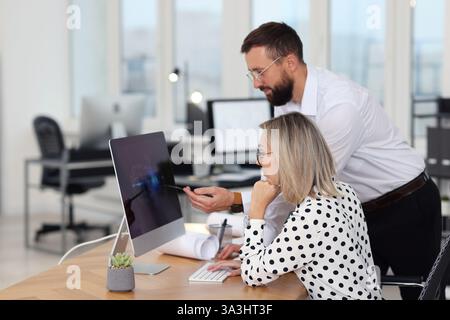 Technicians making digital engineering drawing on computer at desk in office Stock Photo