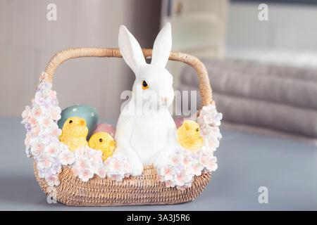 Easter Table Decoration with Bunny, Chicks and Pastel Flowers in Basket Stock Photo