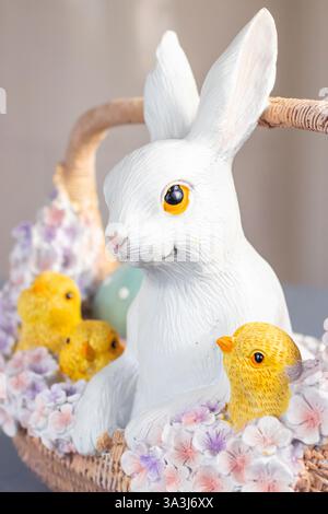 Easter Table Decoration with Bunny, Chicks and Pastel Flowers in Basket Stock Photo