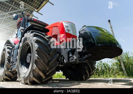 Red tractor on a farm using renewable energy. Stock Photo