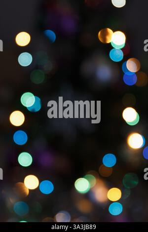 Blurry colorful lights in soft focus on a dark background. Abstract bokeh effect creating a beautiful festive and dreamy atmosphere Stock Photo