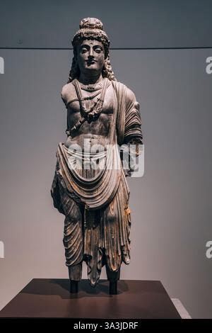 17 January 2025, Louvre museum Abu Dhabi, UAE: Grey stone statue of Buddha standing on a pedestal inside a museum Stock Photo