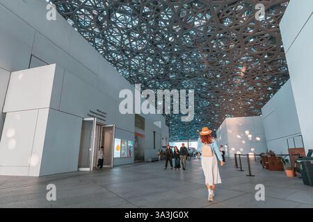 17 January 2025, Louvre museum Abu Dhabi, UAE: Tourists walking inside Louvre museum, enjoying modern geometric ceiling and art exhibitions Stock Photo