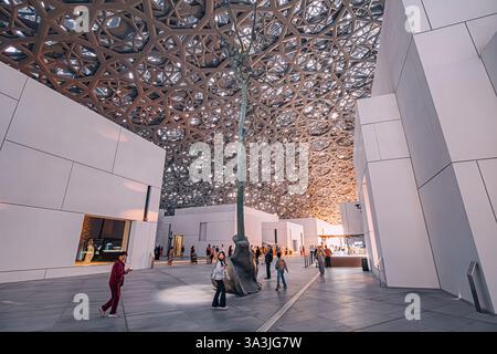 17 January 2025, Louvre museum Abu Dhabi, UAE: Tourists walking inside Louvre museum, enjoying modern geometric ceiling and art exhibitions Stock Photo
