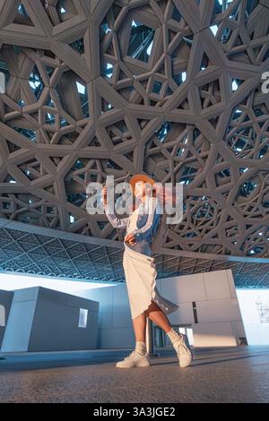 17 January 2025, Louvre museum Abu Dhabi, UAE: Young woman taking selfie under impressive dome of the museum Stock Photo