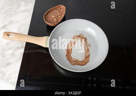 Frying pan with chocolate stain from half an Easter egg. Stock Photo