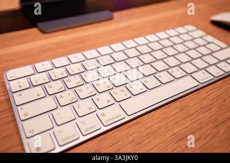 17 January 2025, Abu Dhabi, UAE: Wireless Apple magic keyboard and mouse placed on a wooden desk, creating a minimal and productive workspace Stock Photo