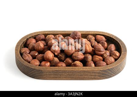 Hazelnuts in a wooden bowl isolated on white background Stock Photo