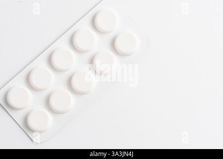 White pills on white background. Top view. Copy space Stock Photo