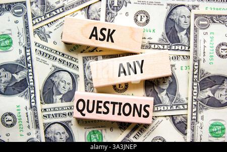 Ask any questions symbol. Concept words Ask any questions on beautiful wooden blocks. Dollar bills. Beautiful background from dollar bills. Business a Stock Photo