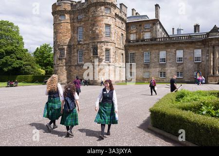 Edinburgh, UK - May 30, 2024. The historic Palace of Holyroodhouse in Edinburgh, UK, with uniformed staff in tartan skirts and visitors exploring the Stock Photo