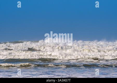 Breaking waves as the tide flows onto a beach. No people. Backgrounds. Stock Photo