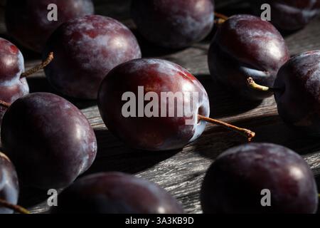 plums on black wood background Stock Photo