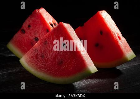 sliced watermelon on black wood background Stock Photo