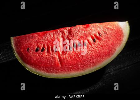 sliced watermelon on black wood background Stock Photo