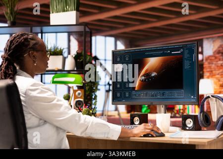 Woman at home getting tasks done with AI program turning text prompt into videos. Person using computer to make use of text to video artificial intelligence generative models Stock Photo