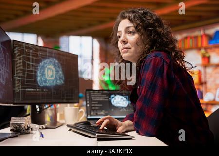System administrator in startup office coding advanced AI algorithm and machine learning models enhancing automation. IT specialist using PC in artificial intelligence Silicon Valley workplace Stock Photo