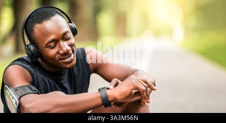 Closeup of happy sportsman looking at his fitness watch Stock Photo