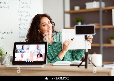 Engaging young Arab woman teaching online in modern e-learning environment Stock Photo