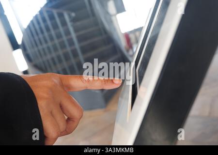User interacting with digital touchscreen at a modern facility Stock Photo