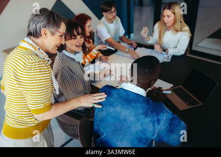 A teacher guides a diverse group of pupils during a collaborative classroom session, fostering engagement and creativity in a vibrant learning environ Stock Photo