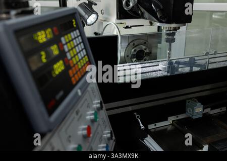 Inside a state-of-the-art manufacturing facility, a milling machine operates with precision as it shapes metal components. Stock Photo