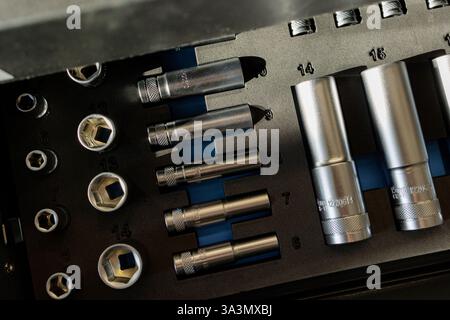 A selection of meticulously arranged metallic sockets in various sizes sits within an industrial toolbox. Stock Photo