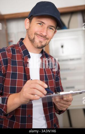 an electrician holding clipboard indoors Stock Photo