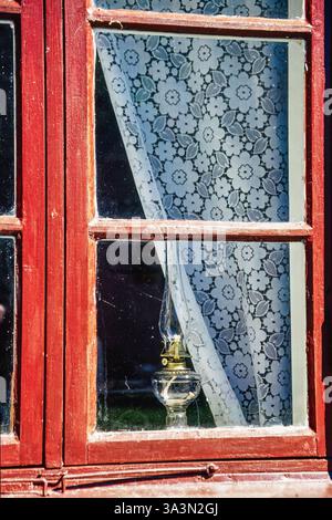Window on an old cottage with a kerosene lamp Stock Photo