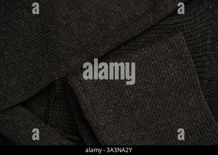 Dark grey sweater texture as a background. Knitted pattern. Top view. Stock Photo