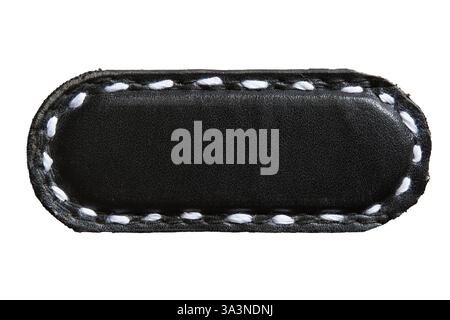 Black capsule shape leather piece with white stitch. Empty leather brand name tag on white background with clipping path. Stock Photo