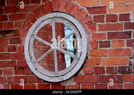 Round window on the brick wall Stock Photo