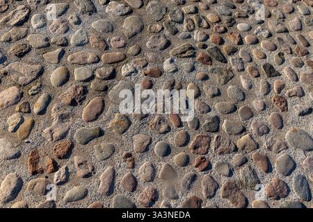 an old-style pavement made of cobblestones of different sizes Stock Photo