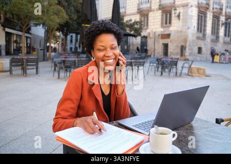 Smiling professional working outdoors on a call Stock Photo