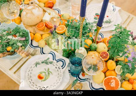 Citrus-themed table setting with vibrant fruit and greenery. Stock Photo
