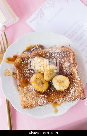 French toast topped with caramelized bananas and powdered sugar. Stock Photo