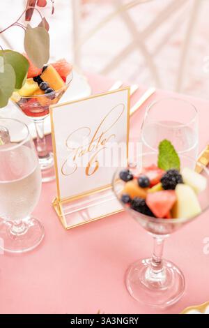 Elegant table setting with fruit cups and table number signage. Stock Photo