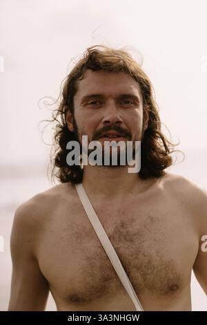 Portrait of a charismatic man with long, curly hair. Stock Photo
