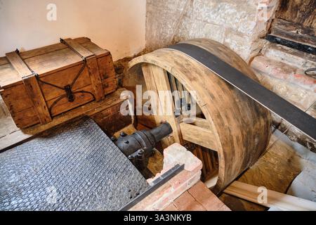 March 16, 2025 - Neubruchhausen-Germany: Restored driving mechanism and shaft driving milling equipment in historic watermill with a leather belt and Stock Photo
