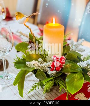 Christmas Table Centrepiece of seasonal foliage and candle Stock Photo