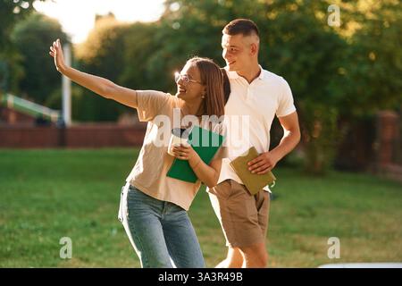 Two students are together outdoors. Stock Photo