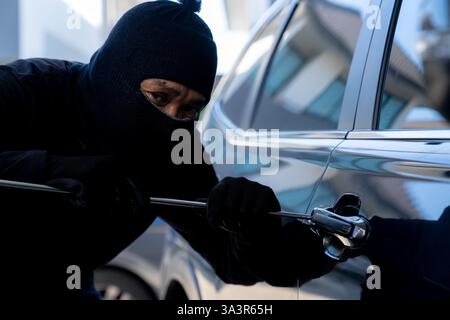 Thief in black jacket various action stolen cars. Stock Photo
