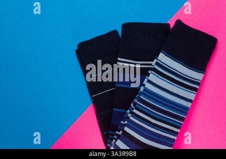 Closeup Details of Multiple Striped Blue Pair of Men's Socks on Blue and Pink Background Horizontal Stock Photo