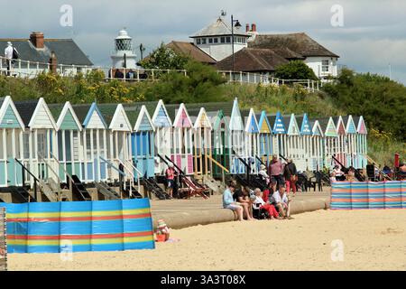 Southwold seafront.  Southwold lighthouse and beach huts seen from Southwold beach in summer, Suffolk, UK. Stock Photo