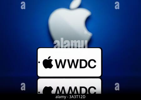 Smartphone displaying WWDC logo with a blurred Apple logo in the background. Apple developer conference and technology event concept Stock Photo