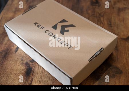 Unique brown box featuring sleek black logo resting on a rustic wooden table with natural light filtering through Stock Photo
