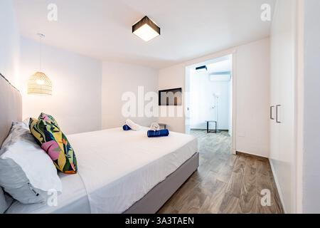 an image of a guest bedroom with fresh towels and private bathroom in mediterranean hotel Stock Photo