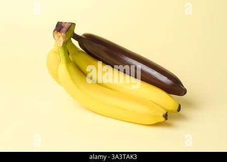 Stop racism. Bunch of yellow bananas with dark one on beige background Stock Photo