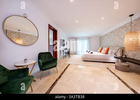 an image of a luxury master bedroom with large bed and private bathroom in holiday villa Stock Photo